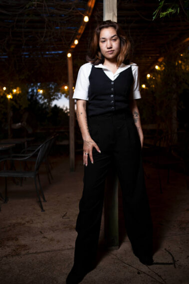 Fashion-style portrait of toxicwoman55 standing confidently beneath hanging lights at Castle Falls during a 1940s-themed photography event.